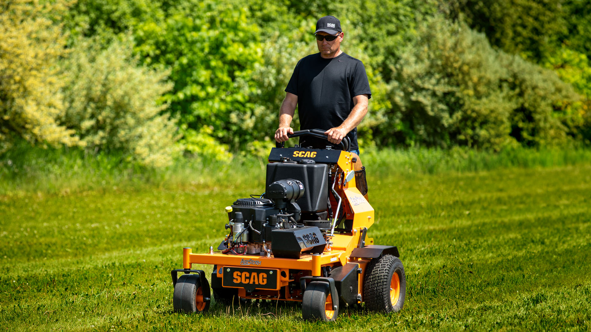 Man using an AerStorm aerator on a green lawn