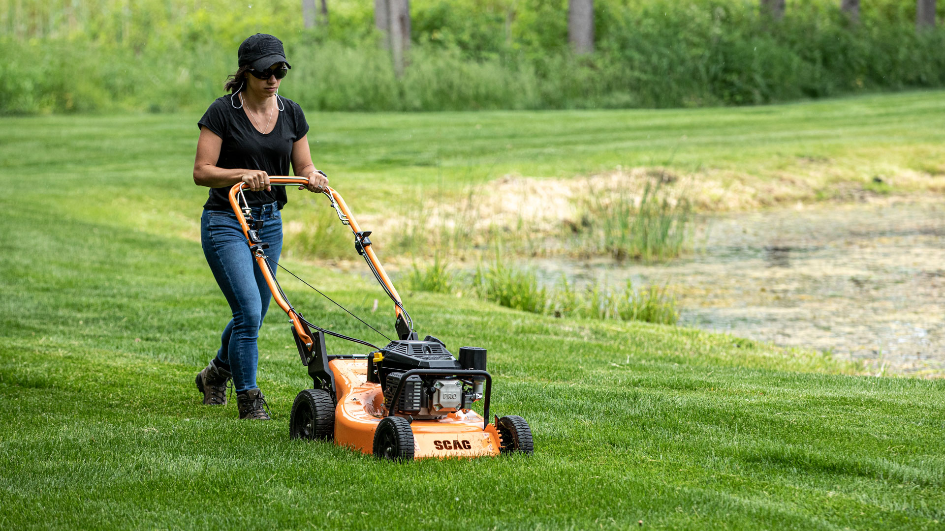 Woman pushing a SFC-21 mower on a green lawn